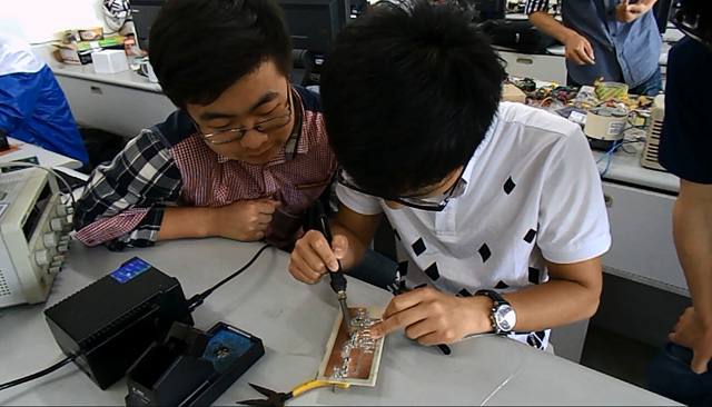 1453860582382429.jpg 实验室成员正在调试电路.jpg