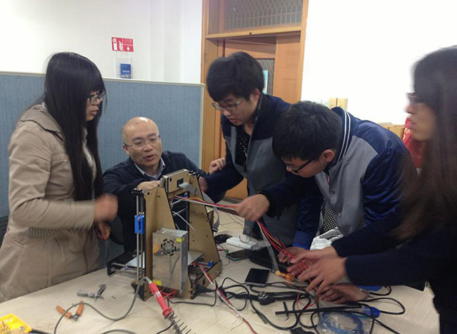 专业导师严义与计算机科学与技术专业学生讨论3D打印机的工作原理.jpg